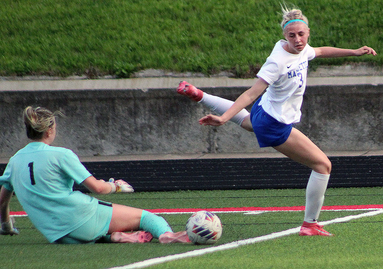 Alton goalie Lyla Cowan (1) slides out to make a save against Marquette's Alex Stephan during Friday's game at Public School Stadium.
