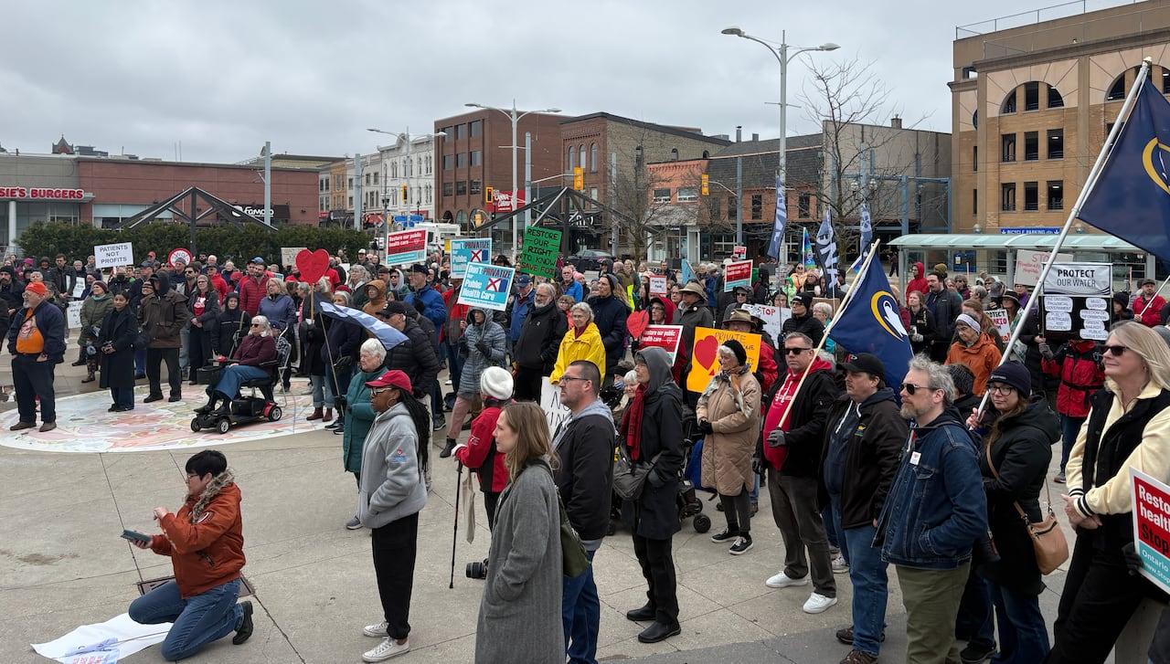 People standing around in a crowd holding up signs