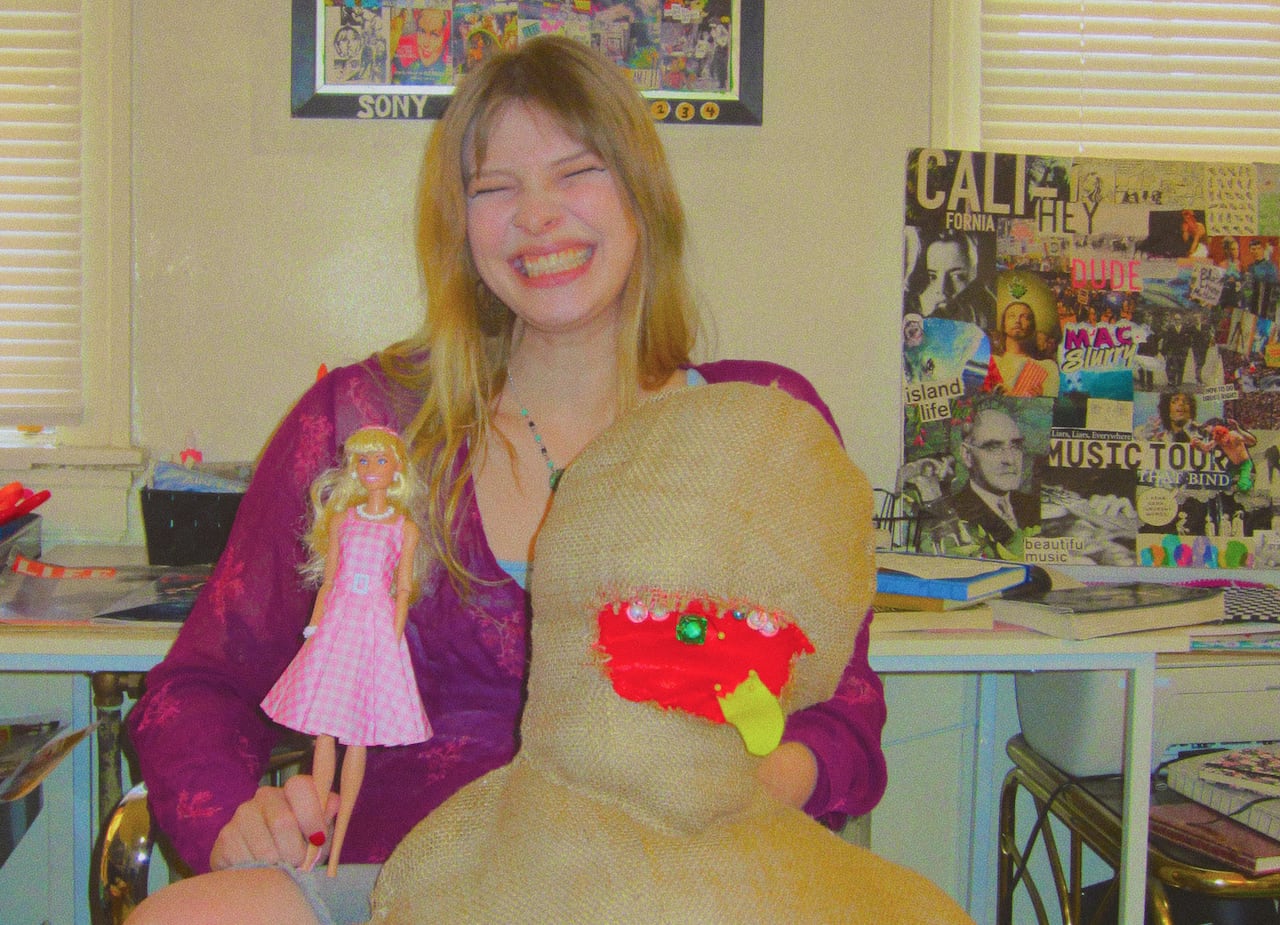 A woman holding a large and a small doll.