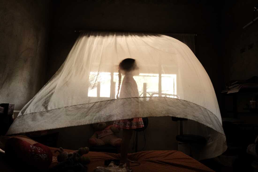 Title: Name the Absence Credit: © Ferley A. Ospina Caption: Valeria (5) plays behind a curtain at her aunt’s house. She is raised solely by her mother. In her region, 30% of households are headed exclusively by women. 10 September 2025 in Los Patios, Norte de Santander, Colombia. Story: Colombia has the world’s highest rate of single mothers. The photographer and his family experience this reality not as a statistic but as a “recurring wound.” In 1999, Ferley Ospina’s father was murdered in the border region of Norte de Santander, forcing him to flee with his mother. Photographing the women in his extended family, Ospina seeks to understand the “weight of absence” and the systemic and personal impact of “growing up incomplete.”