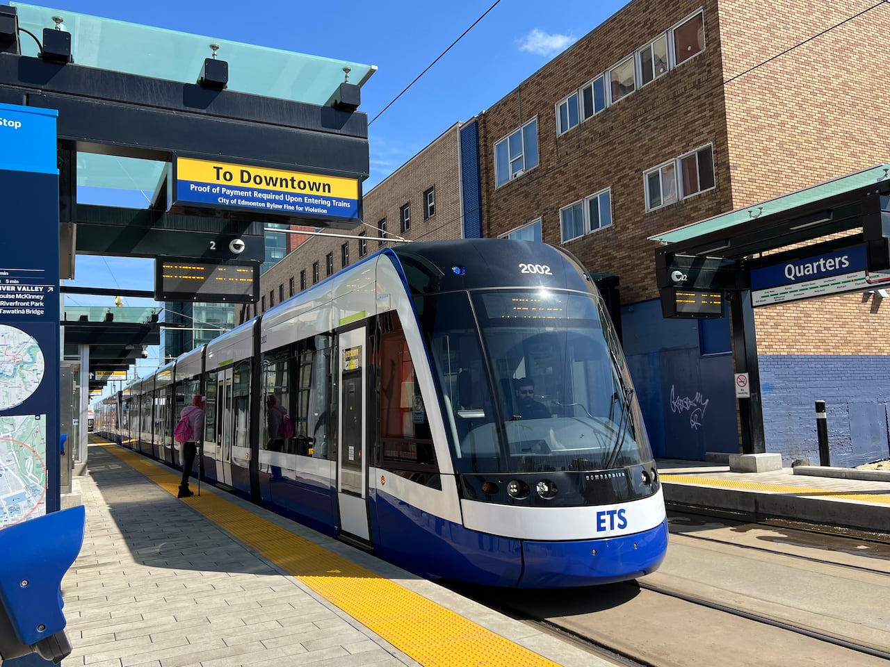 A wide shot of the Quarters LRT station as a train pulls up to the stop.