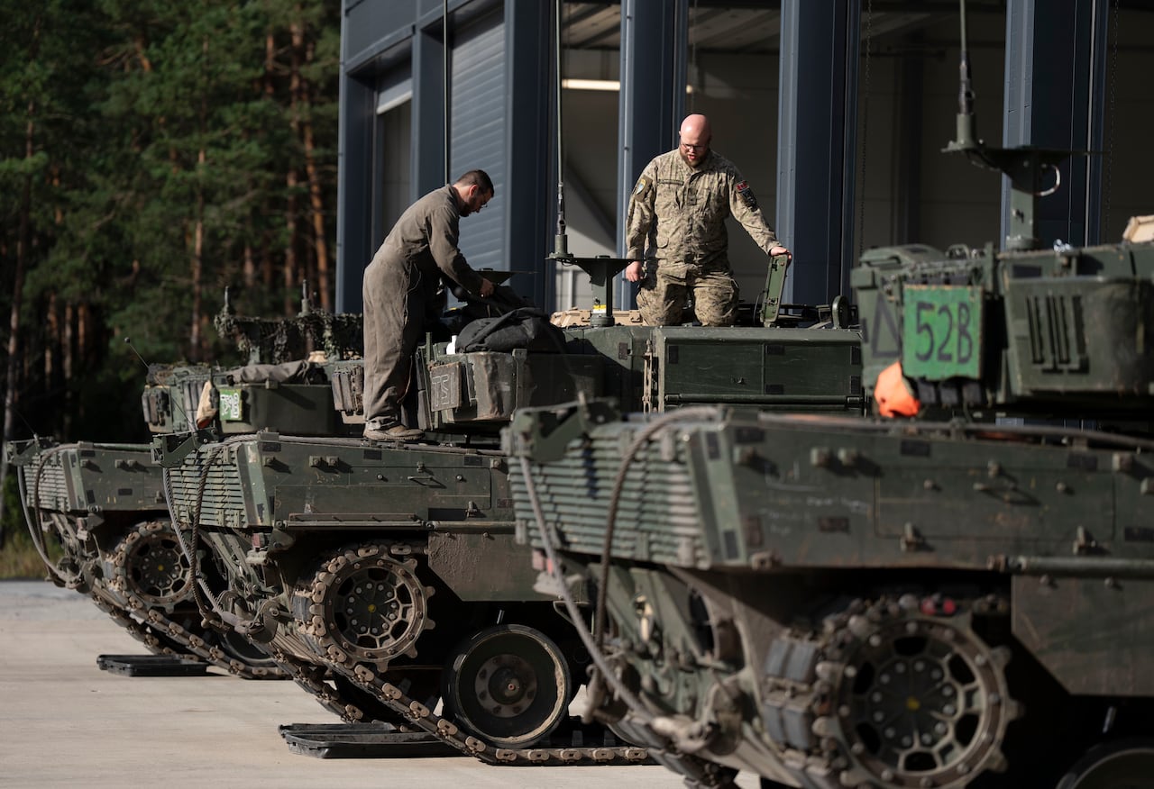 Soldiers fix an armoured vehicle.