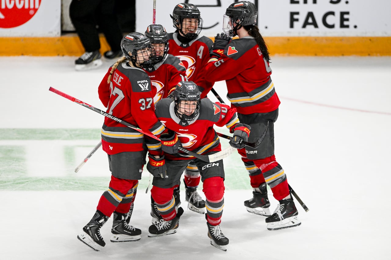 Hockey players celebrate together at centre ice.
