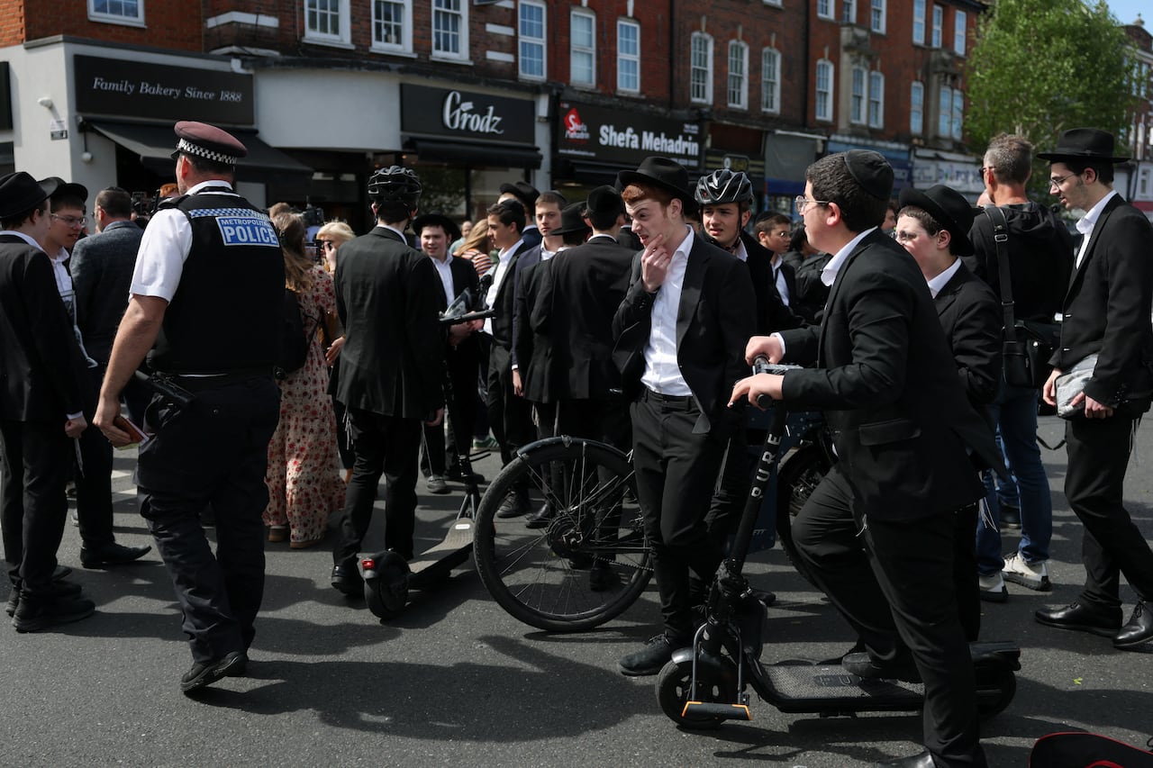 A police officer walks next to locals.