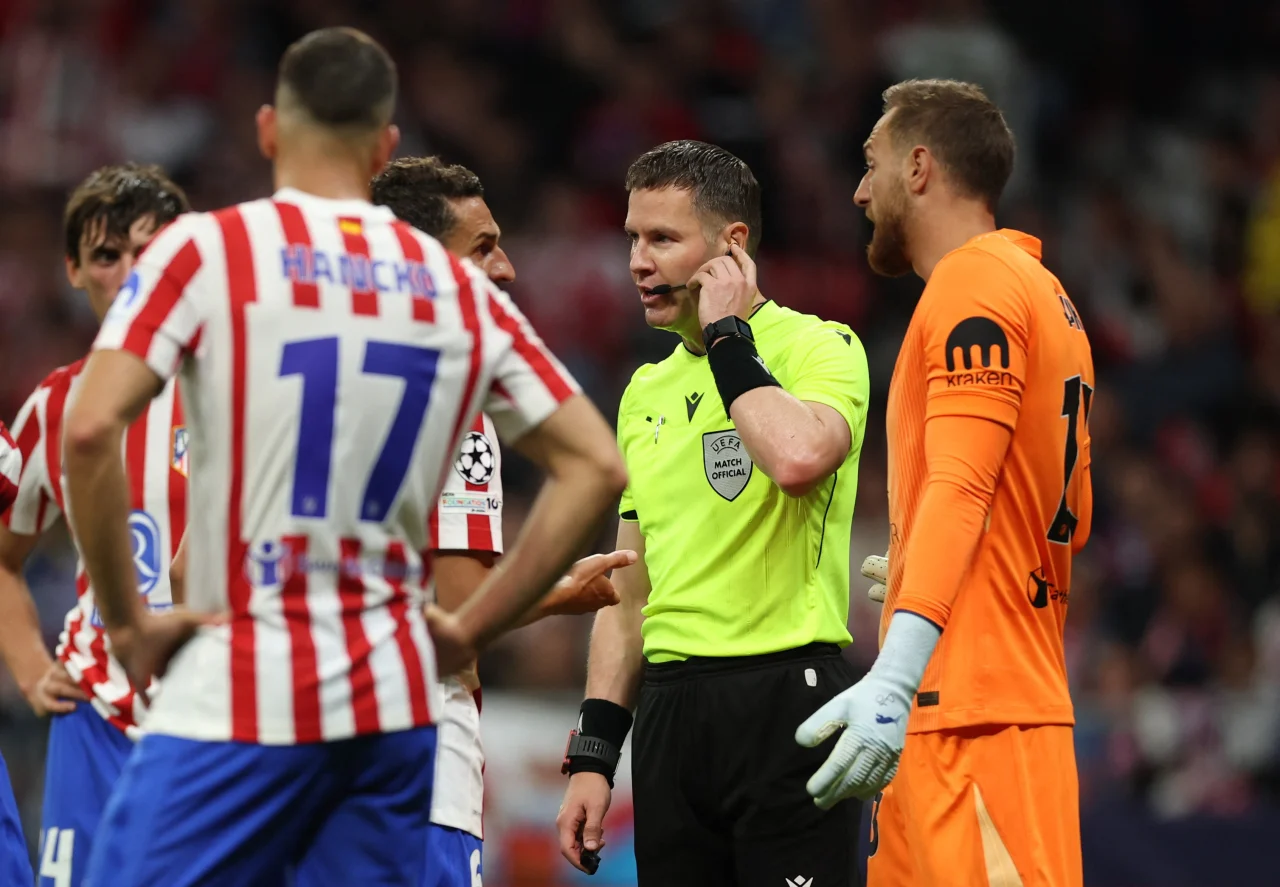 Referee Danny Makkelie listens to a VAR review for a possible penalty.