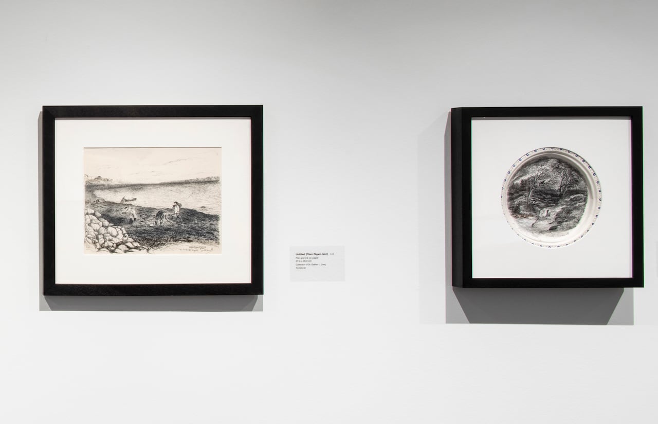 Two framed pen drawings, one showing clam diggers on a rocky coast, the other showing a creek and trees.
