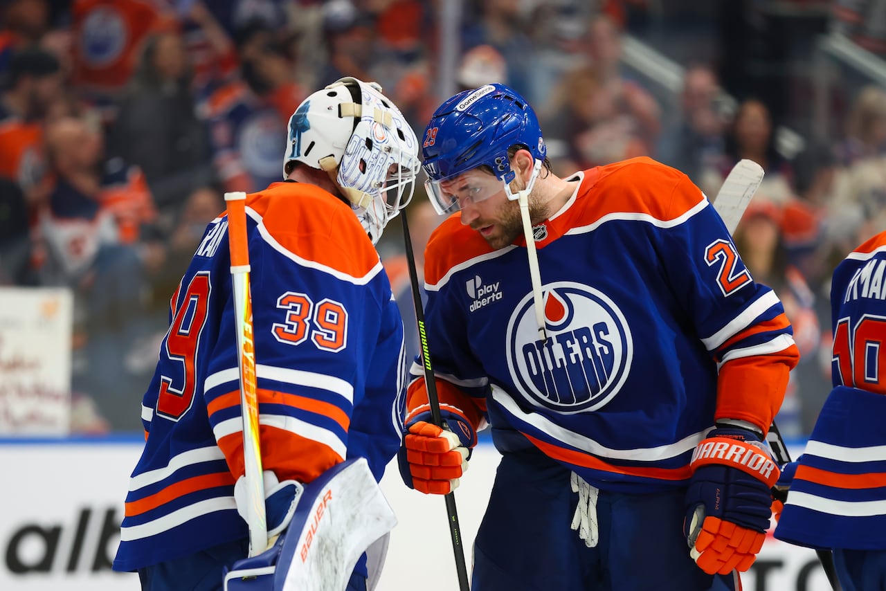 A goaltender and a hockey player butt heads.
