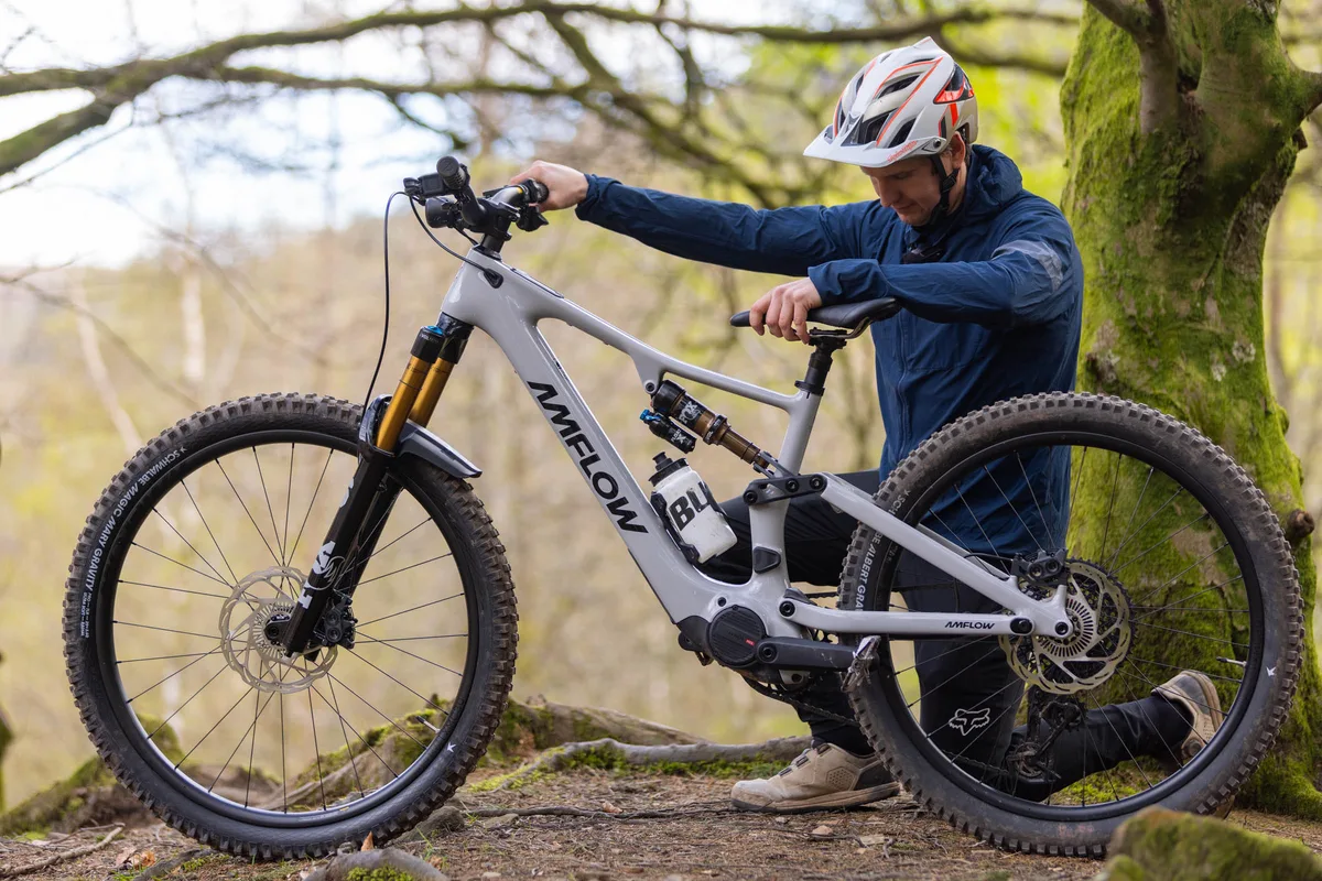 Rider stationary with an e-mountain bike in a wooded area