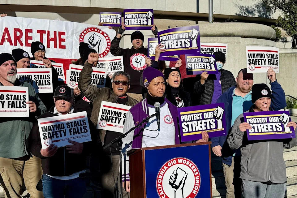 Demonstrators hold signs during a protest by Uber and Lyft drivers asking state regulators to take self-driving taxis off the streets due to safety concerns at the California Public Utilities Commission headquarters Friday, Jan. 9, 2026, in San Francisco.