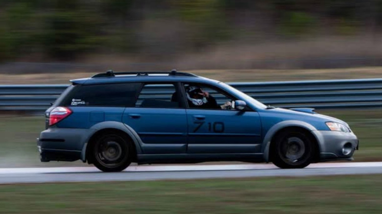 A blue Subaru Outback XT on track