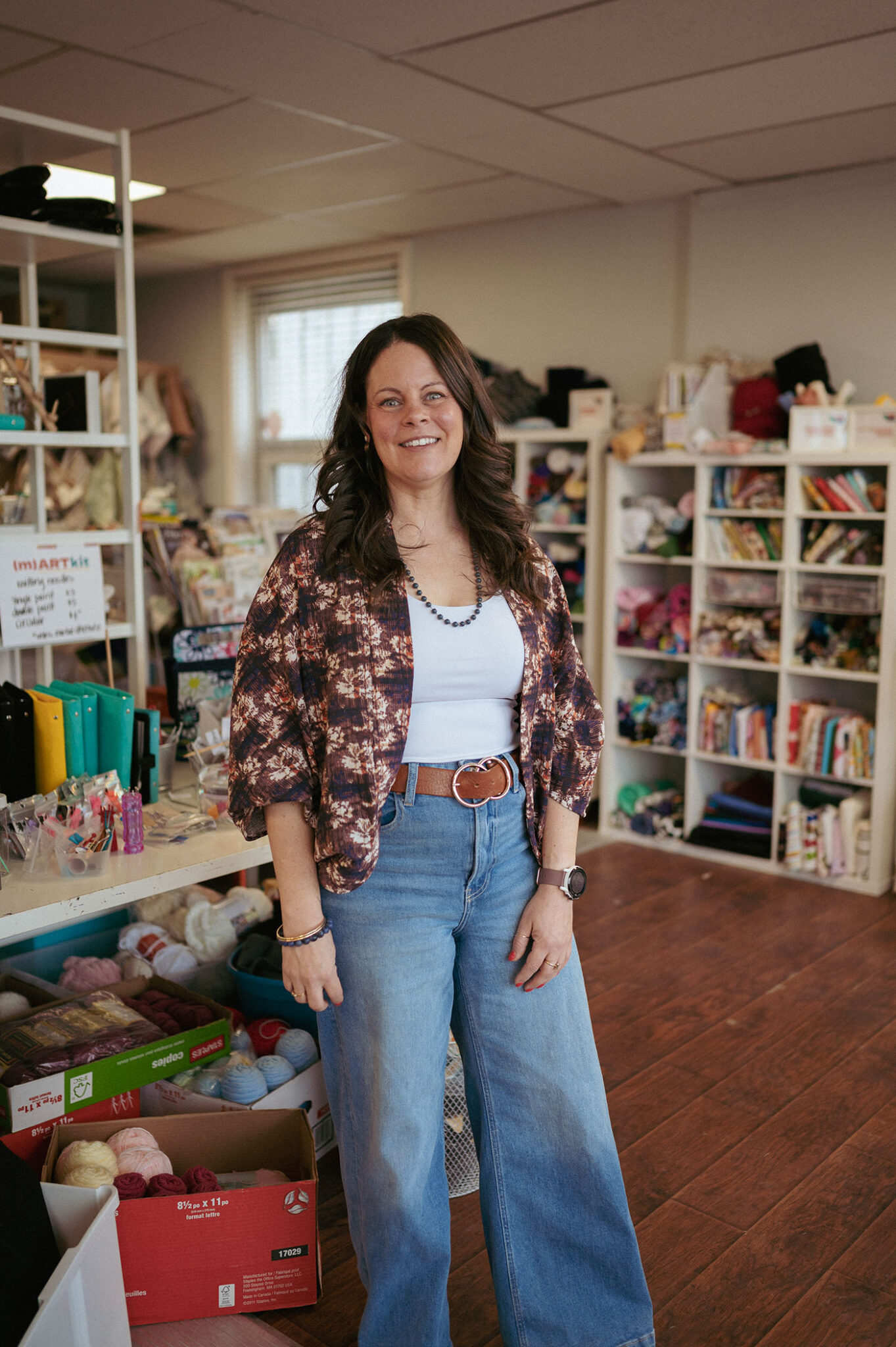 A woman poses for a photograph inside an art supply store.