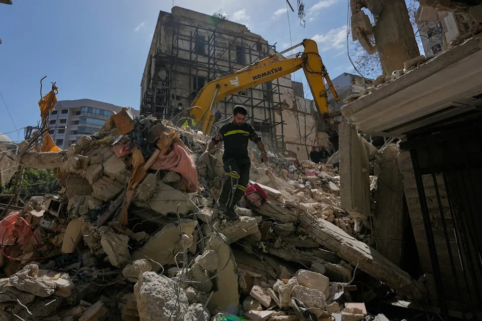 A Lebanese civil defense worker walks on the rubble of a building destroyed in an Israeli airstrike a day earlier in Beirut, Lebanon, Thursday, April 9, 2026. (AP Photo/Hussein Malla)