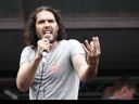 British comedian Russell Brand speaks to protesters following a march against the British government's spending cuts and austerity measures in London on June 20, 2015. 