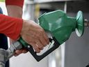 A person pumps fuel at a gas station.