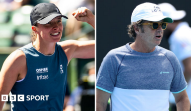 Iga Swiatek holds up her arm and Francisco Roig is wearing a hat and sunglasses