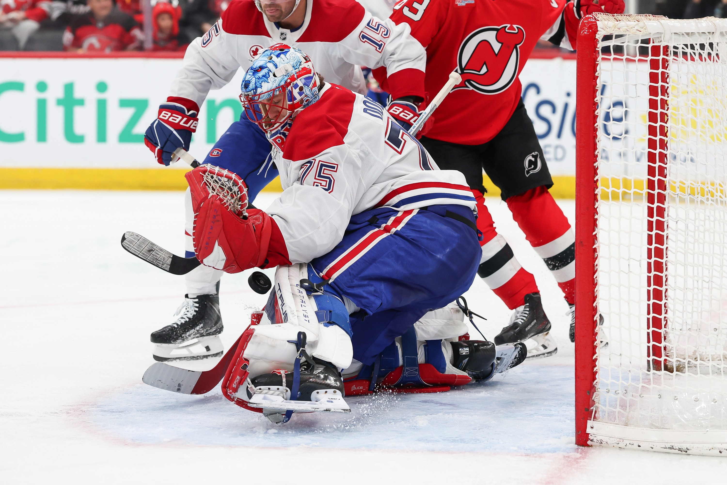 Hockey goalie makes a save in traffic. 