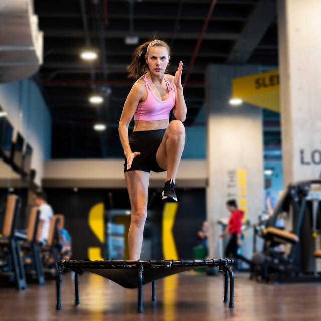 Latin woman at the gym exercising on a trampoline Latin woman at the gym exercising on a trampoline