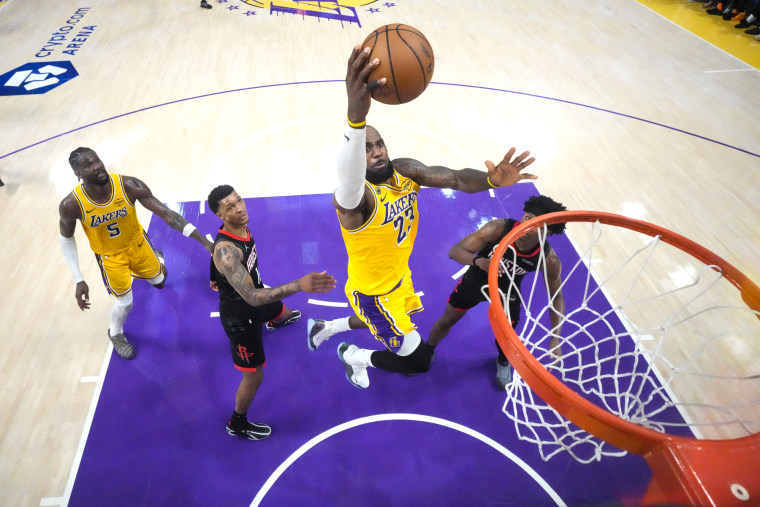 LeBron James jumps to shoot a basketball into the hoop