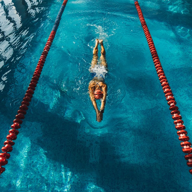 View from above of woman swimming by track in the pool. Sports concept, unrecognizable person. View from above of woman swimming by track in the pool. Sports concept, unrecognizable person.