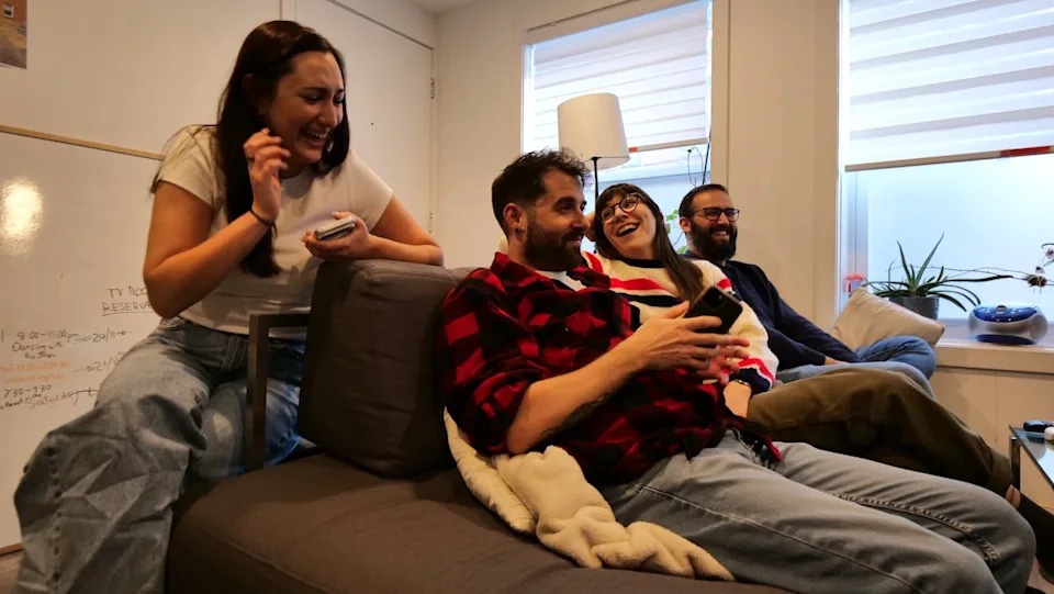 Four housemates share a moment in the living room of the Nomad Co-living house in Hochelaga-Maisonneuve in Montreal.