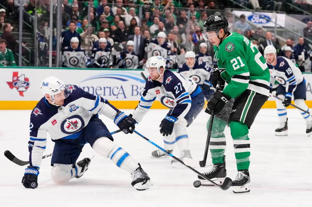 TONY GUTIERREZ / THE ASSOCIATED PRESS
Winnipeg Jets defenceman Dylan DeMelo (2) strips the puck away from Dallas Stars left wing Jason Robertson (21) on an attack in the first period of Thursday’s game.