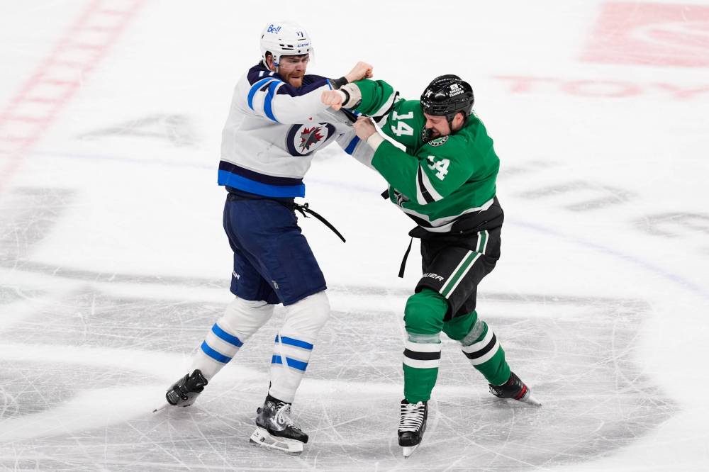 TONY GUTIERREZ / THE ASSOCIATED PRESS
Winnipeg Jets centre Adam Lowry, left, and Dallas Stars left wing Jamie Benn (14) fight in the third period of Thursday’s game.