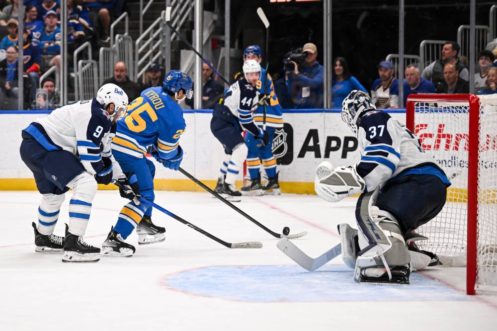 Connor Hamilton / The Associated Press
Winnipeg Jets Alex Iafallo and goaltender Connor Hellebuyck defend against St. Louis Blues’ Jordan Kyrou during the second period.