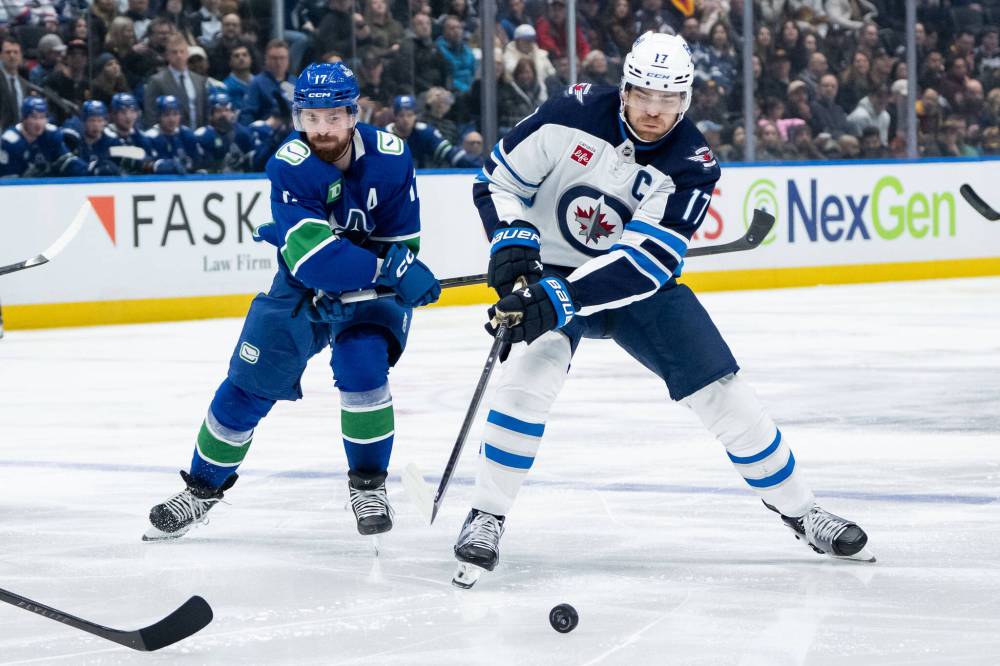 ETHAN CAIRNS / THE CANADIAN PRESS FILES
Winnipeg Jets captain Adam Lowry (right) says it’s possible he came back from off-season hip surgery a bit too soon.