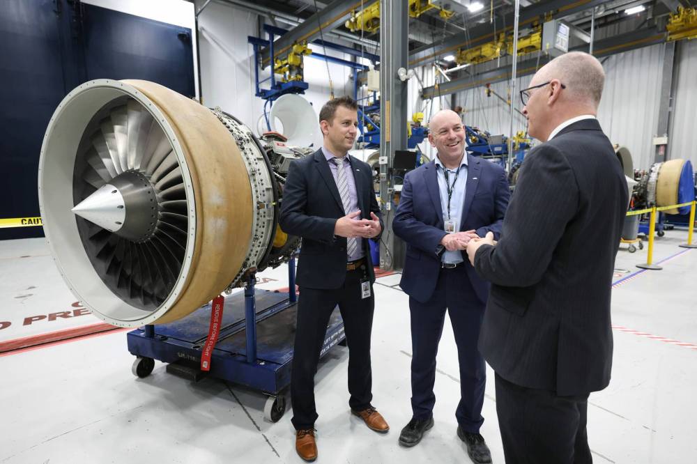 Ruth Bonneville / Free Press
StandardAero’s Peter Wheatley and Chad Flowers chat with Winnipeg Mayor Scott Gillingham after the announcement Friday.
