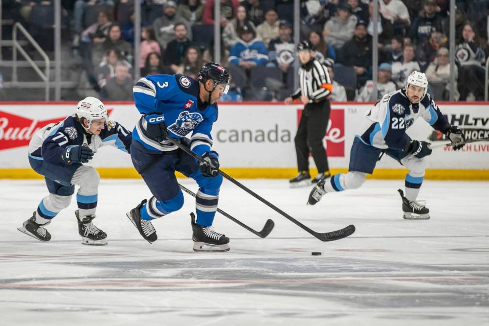 BROOK JONES / FREE PRESS
Manitoba Moose defenceman Isaak Phillips (No. 3) controls the puck while Milwaukee Admirals right-winger Cole O’Hara (No. 77) reaches for the puck during first period action.