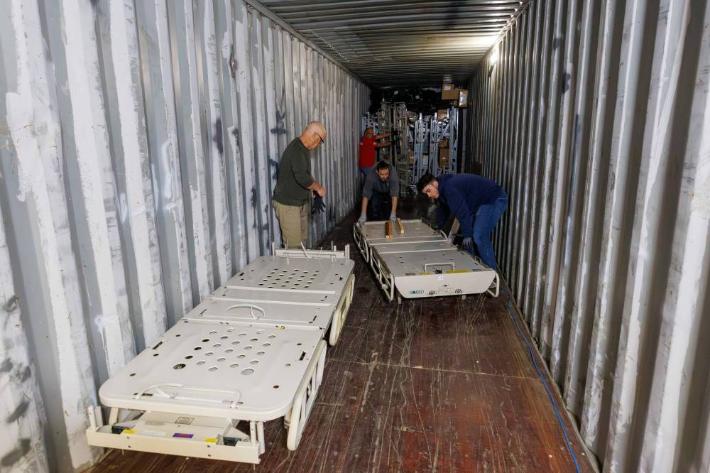 MIKE DEAL / FREE PRESS
Volunteers pack a shipping container with hospital beds.