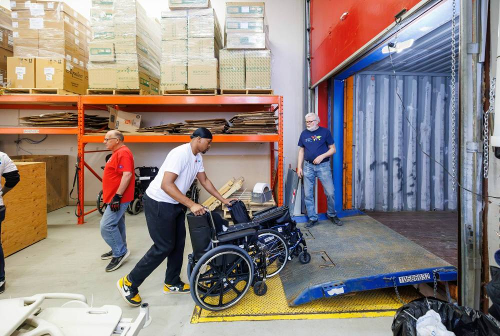 MIKE DEAL / FREE PRESS
Volunteers load wheelchairs into the container.