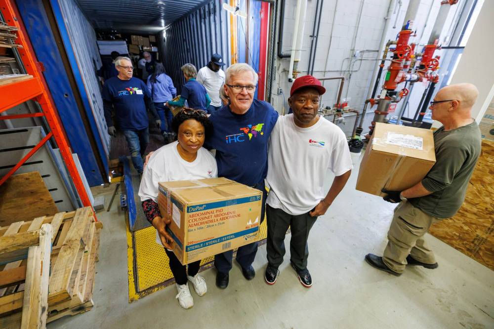 MIKE DEAL / FREE PRESS
Kevin Stewart (centre), president of International Hope Canada, with Kanko Mansaray (left) and Abdulai Konteh (right), as volunteers load a shipping container with medical supplies.