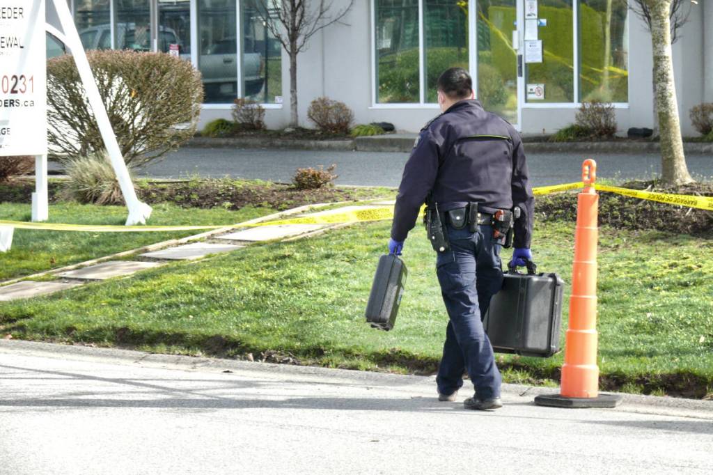Investigators are seen after a shooting in the 5400-block of Production Boulevard March 23. Police say more shots were fired at the business complex in the early hours of March 30. (Dan Ferguson/Langley Advance Times)
