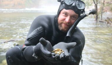 Paul Larouche stands in Sooke River with a handful of gold he has previously found. (Ben Fenlon/Sooke News Mirror)