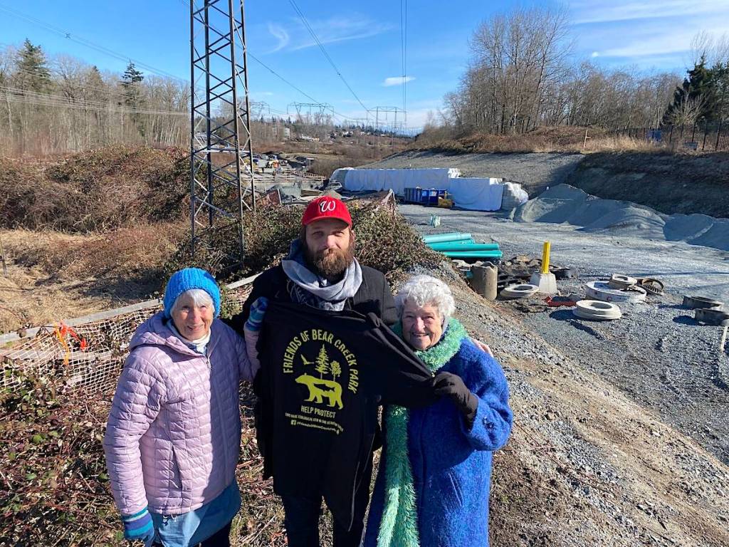Friends of Bear Creek Park group members, from left, Evelyn Zaklan, Sebastian Sajda and Annie Kaps on a hill overlooking the 84 Avenue extension project in Surrey on Feb. 23, 2023. (Photo: Tom Zillich)