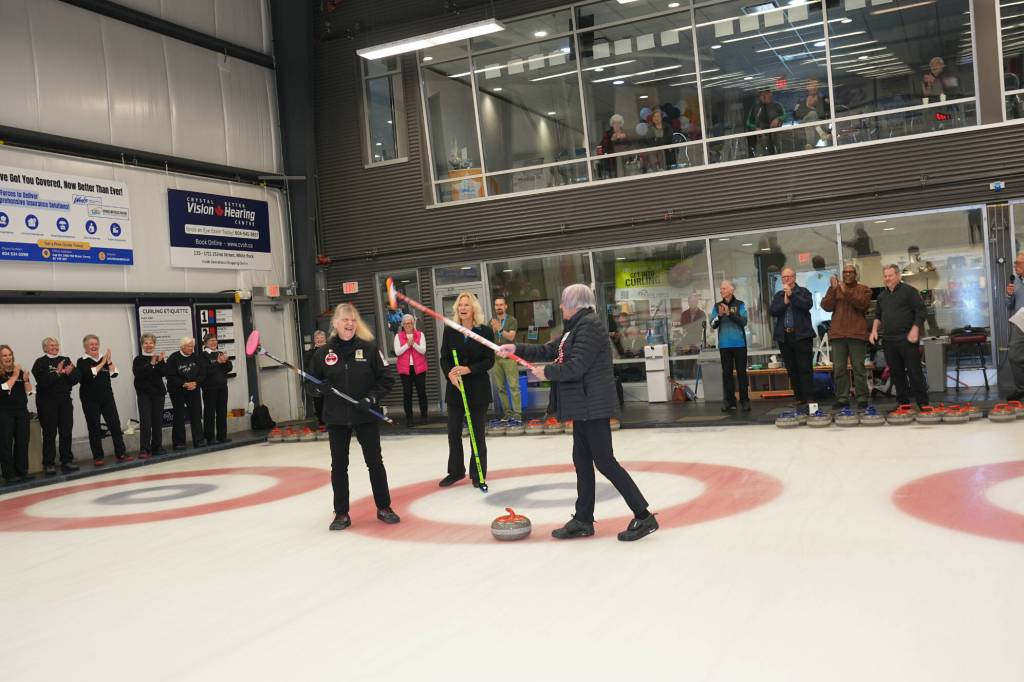 Pat Elliott, left, White Rock Mayor Megan Knight, and Cathy Stewart participate in the delivery of the ceremonial opening stone at the Peace Arch Curling Club&rsquo;s Nifty Fifty Provincial Senior Ladies bonspiel. (Leo Le Couteur photo)