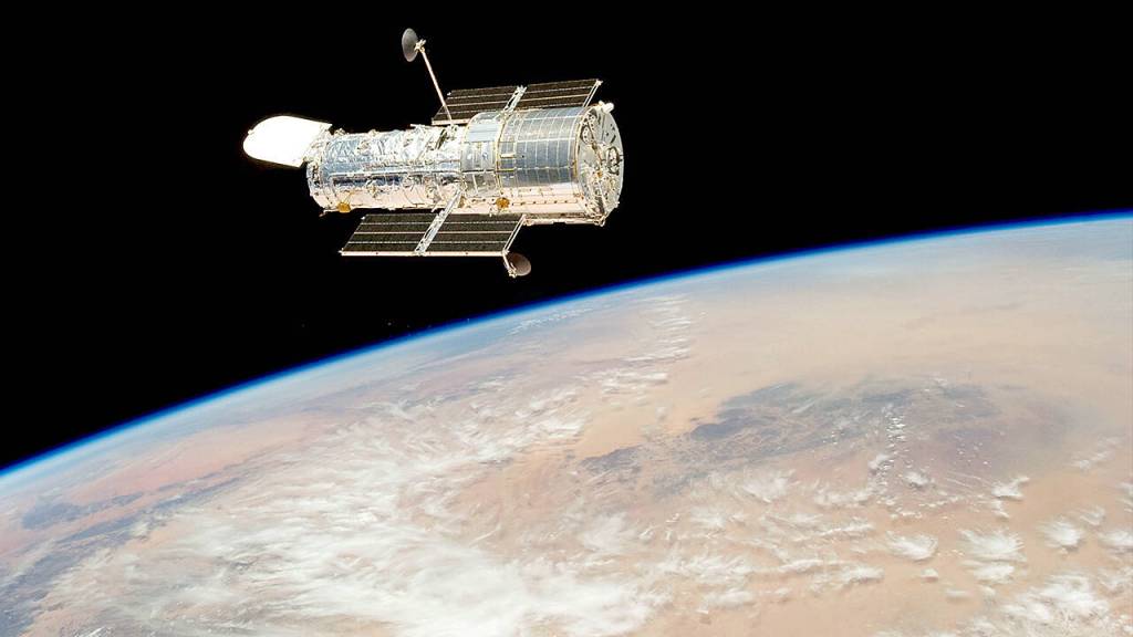 The Hubble Space Telescope drifts over Earth after its release in 2009 by the crew of the Space Shuttle Atlantis. The crew had performed all planned tasks during the fifth astronaut visit to the telescope. (NASA)