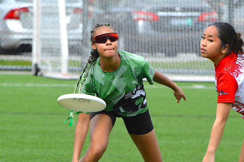 Thea Highwarden with Guildford Park Sabres ultimate team (in green) throws the disc during a game with Holy Cross Crusaders at Hjorth Road Park in Surrey on April 10, 2026. (Tom Zillich/Surrey Now-Leader)