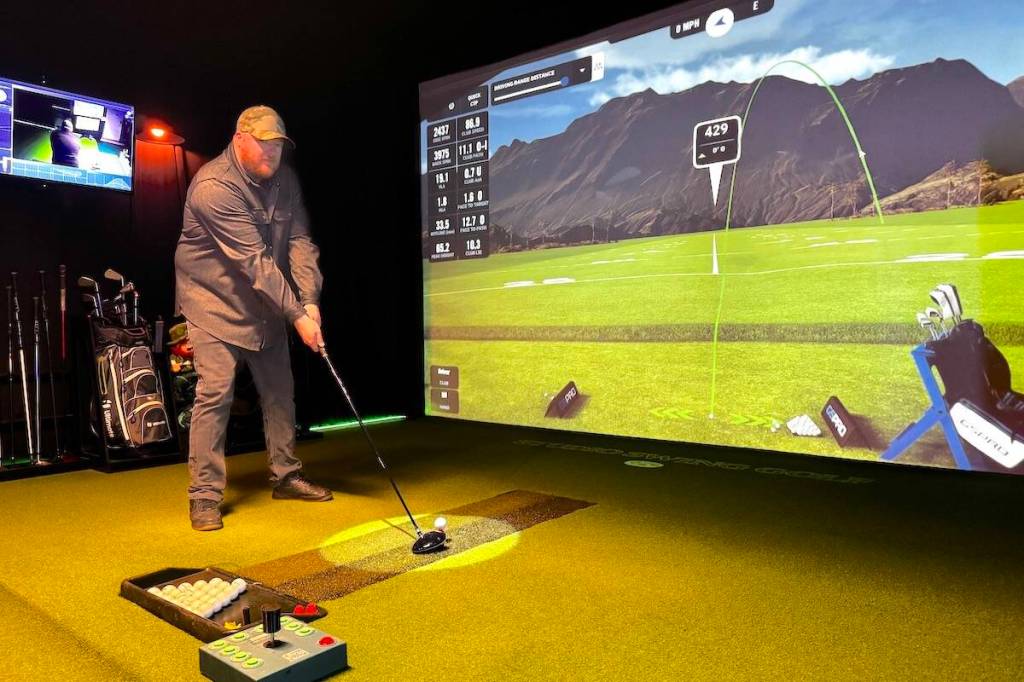 Jordie MacKay at the Studio Swing golf simulator he built and operates in a Surrey garage. (Tom Zillich/Surrey Now-Leader)