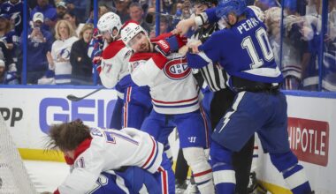 Canadiens and Lightning players fight each other behind the net.