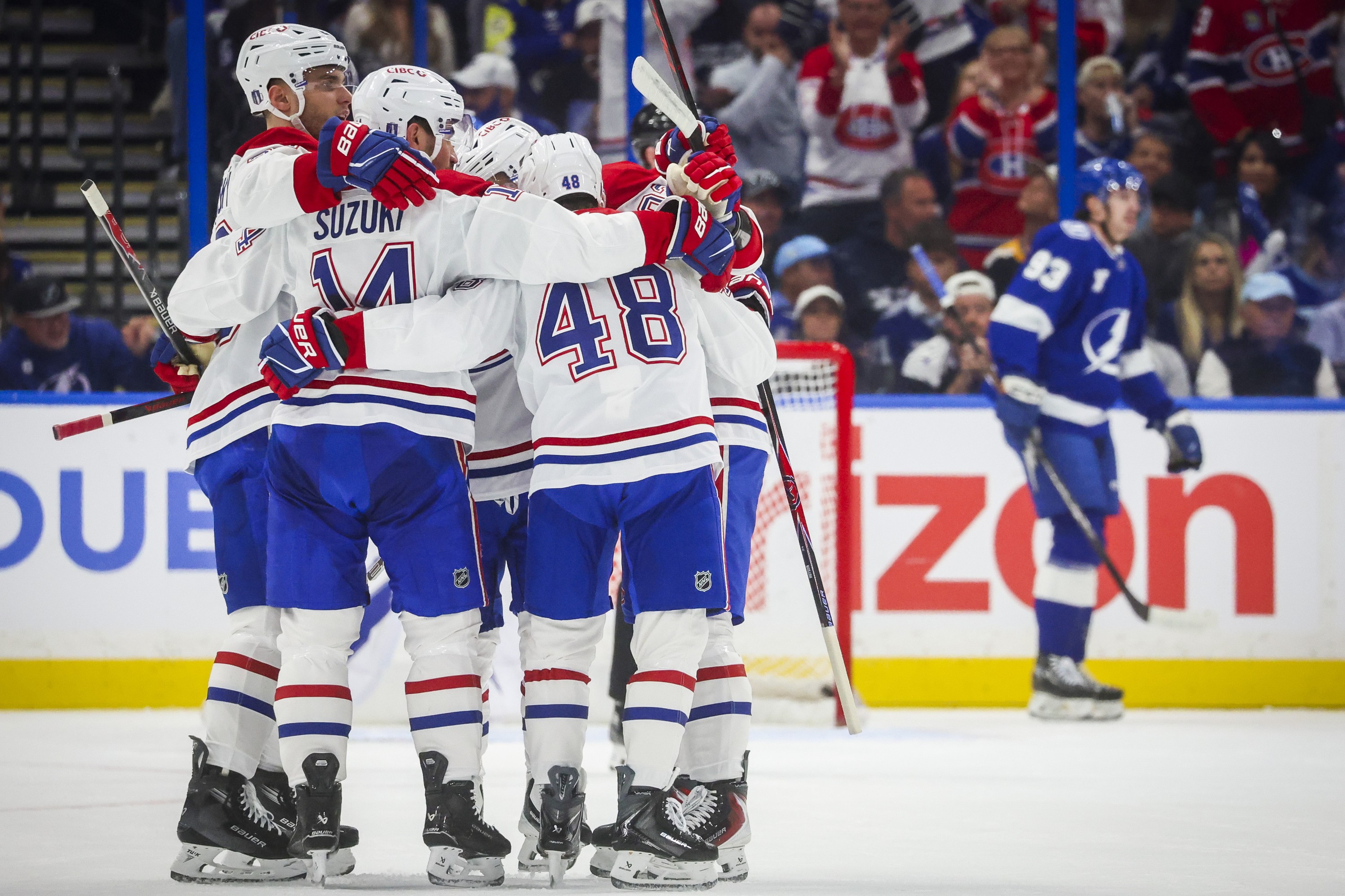 Canadiens players embrace each other in celebration on the ice.