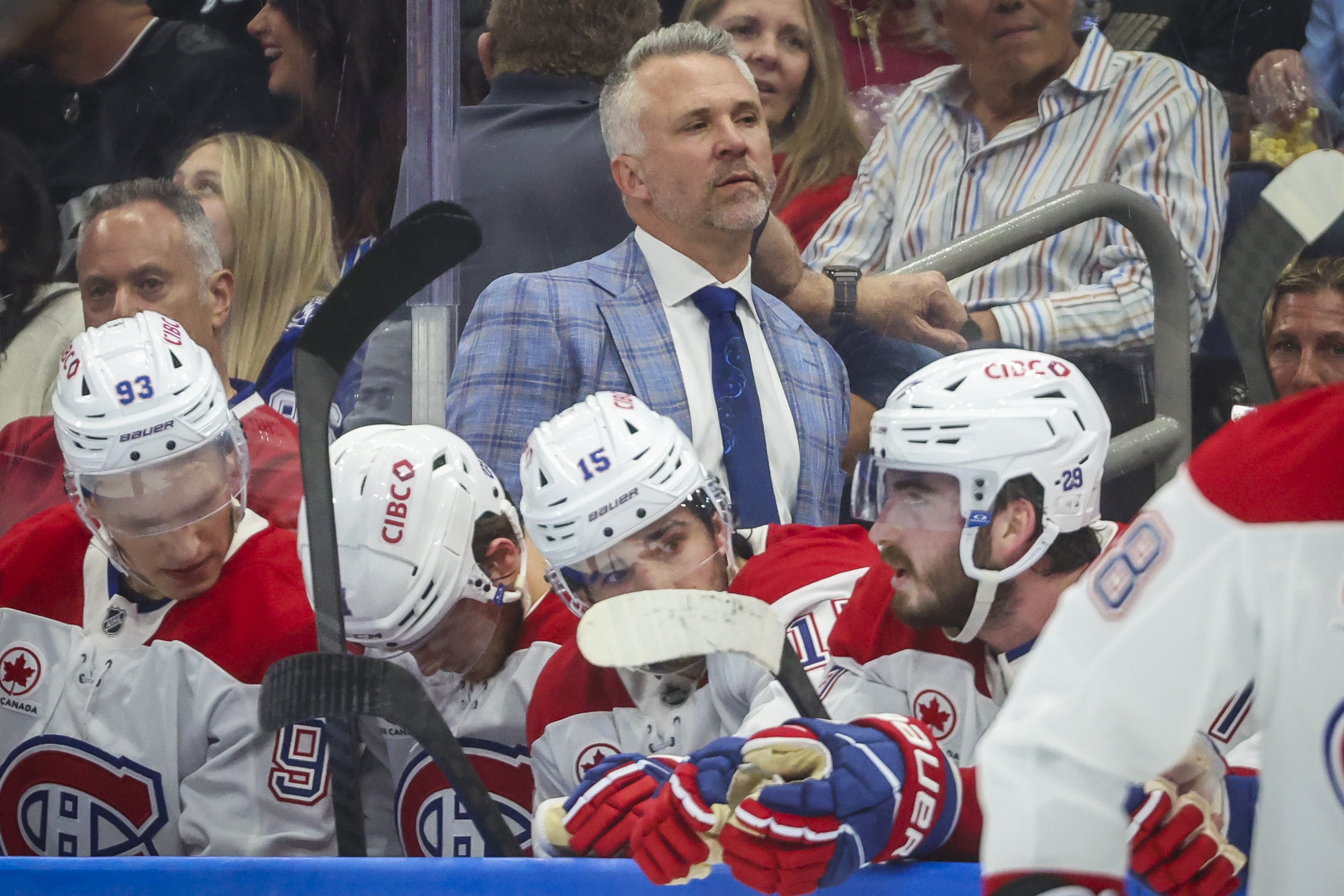 Canadiens coach Martin St. Louis is seen along the bench behind players.
