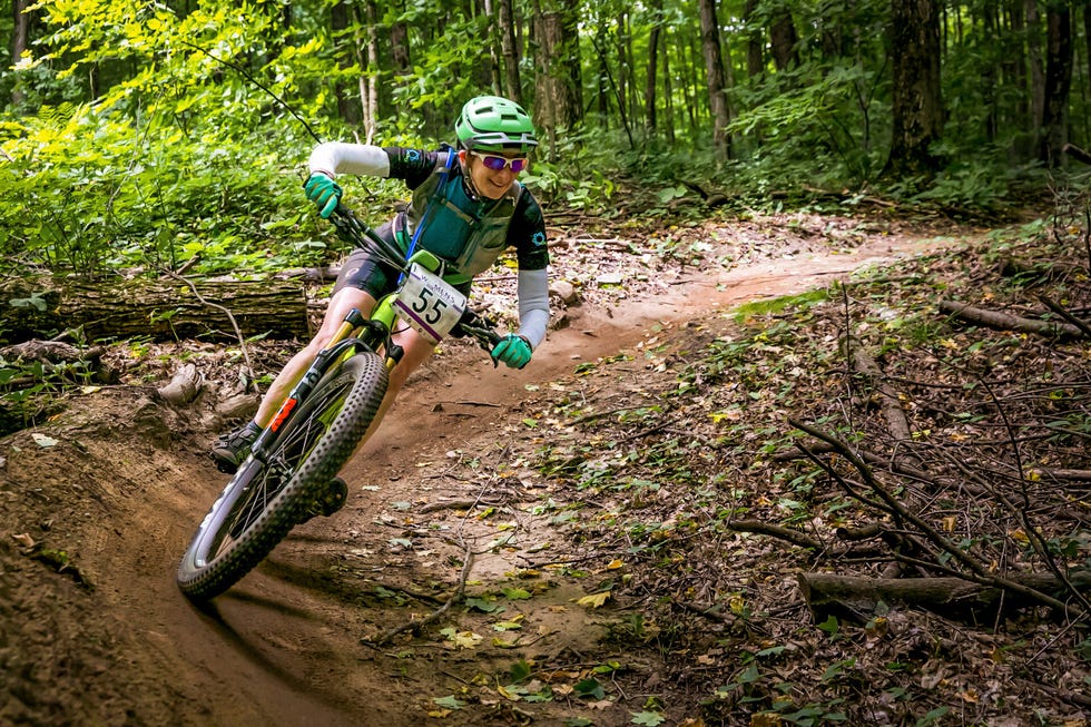 Mountain biker navigating a curved trail through a lush forest. Mountain biker navigating a curved trail through a lush forest.
