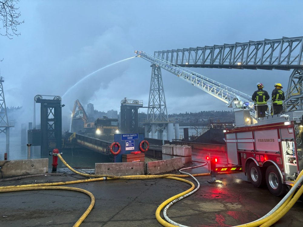 Firefighters are seen during operations to extinguish a fire on a barge in Surrey, B.C., in a Friday, April 3, 2026, handout photo. The Metro Vancouver Regional District says it's monitoring air quality after a barge fire sent considerable smoke into the air. THE CANADIAN PRESS/Handout — Metro Vancouver Regional District (Mandatory Credit)