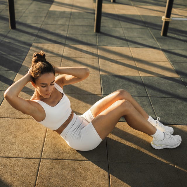 Woman training abs muscles on sports ground. Street workout and sports concept. Woman training abs muscles on sports ground. Street workout and sports concept.