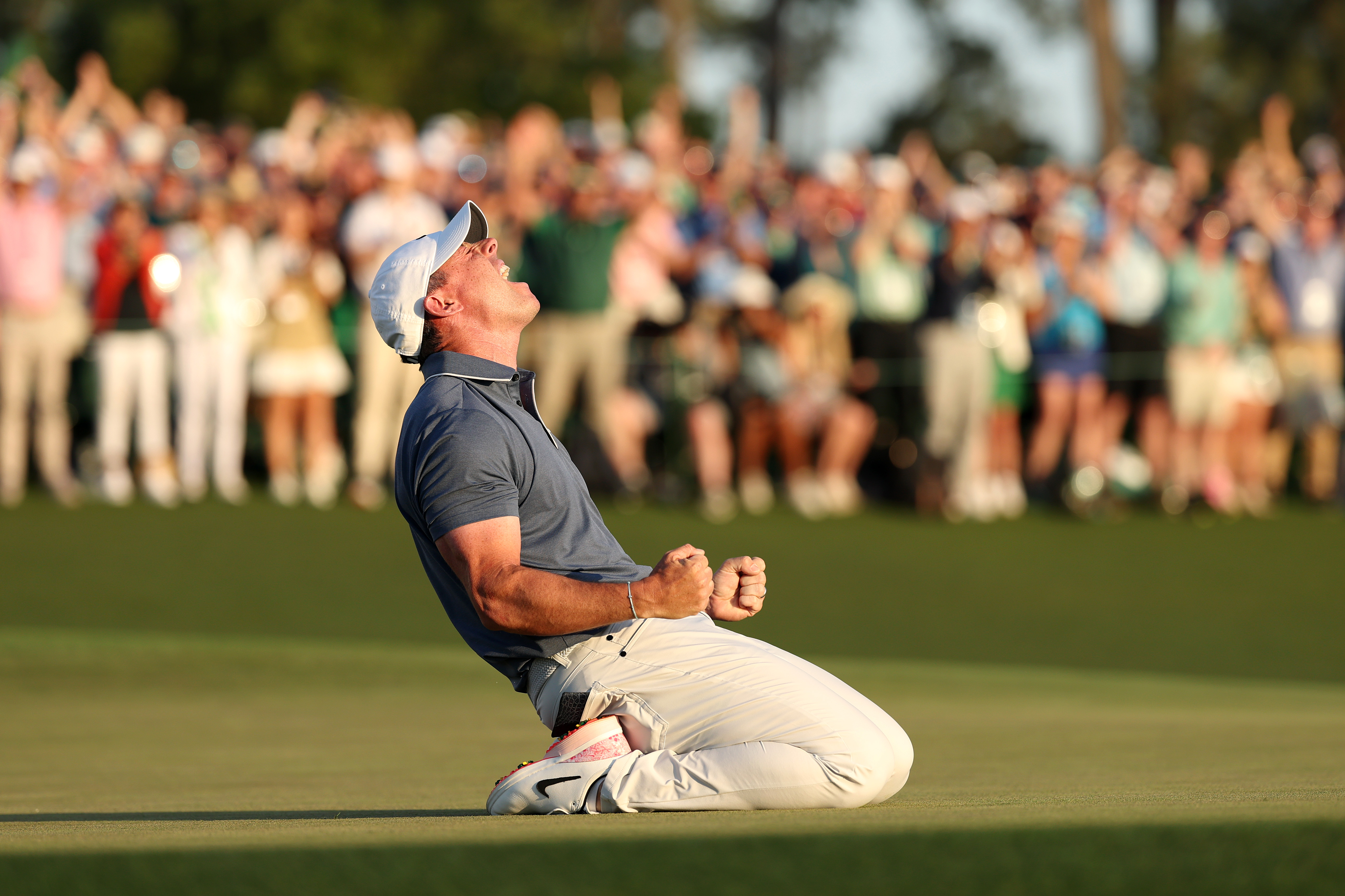 Rory McIlroy on his knees celebrating winning the 2025 Masters