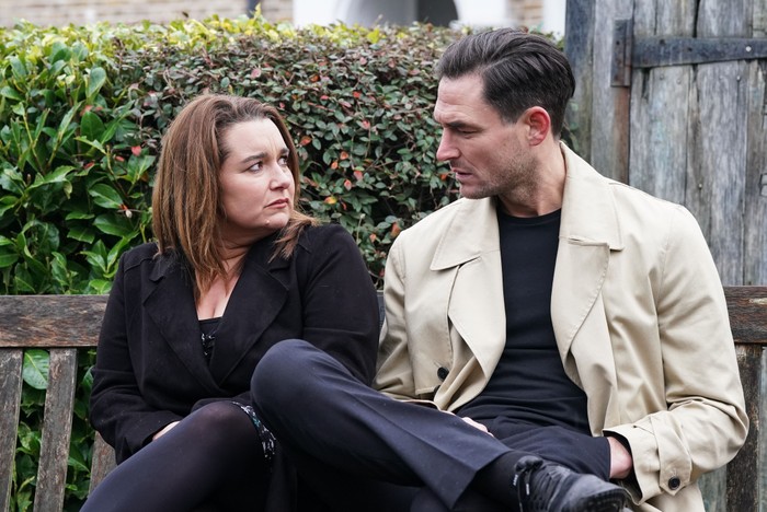 556113,TITLE:Eastenders Vicki and Zack stare into one another's eyes with worried expressions on their face, sat in the Square gardens in EastEnders