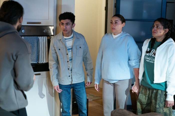 Nugget, Priya and Avani hold hands staring in Ravi's direction in EastEnders