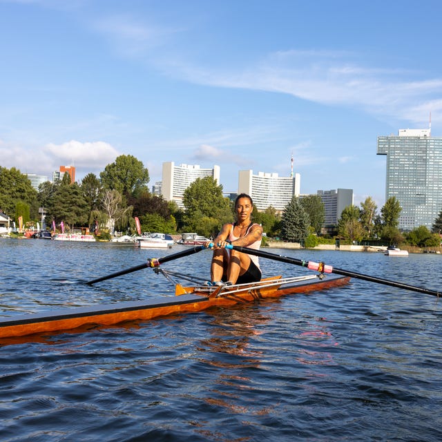 Woman rowing single scull boat, morning workout on the Danube river, Vienna, Austria Woman rowing single scull boat, morning workout on the Danube river, Vienna, Austria